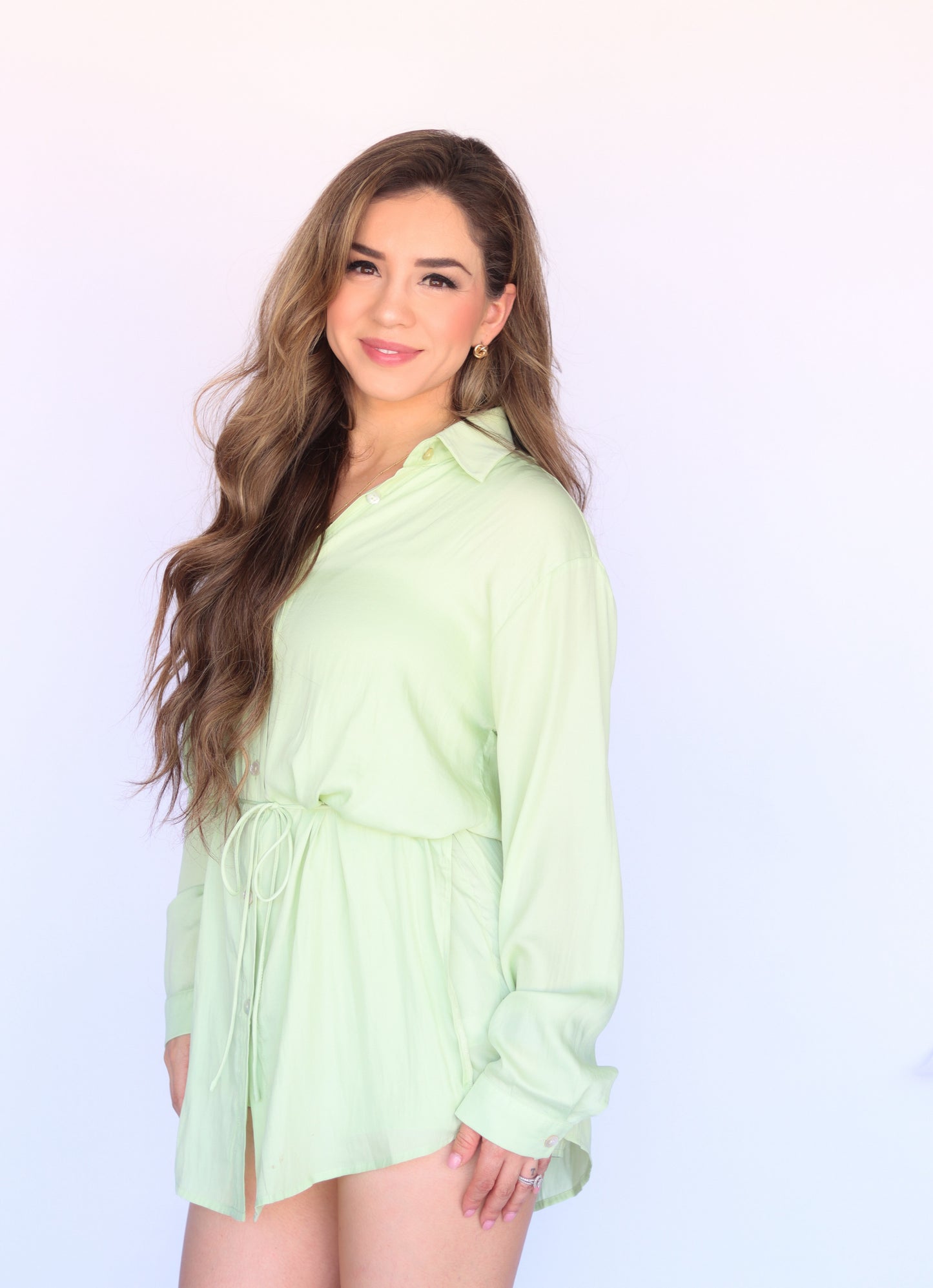 Introducing the Mellow Green Romper - your new go-to for effortless style. This satin piece features a layered design, button-front closure, and removable tie belt for a customizable fit. With a dress shirt overlayer and shorts lining, this romper offers a relaxed fit and side slits for added comfort. Elevate your wardrobe with this thigh-length, high-waisted gem.