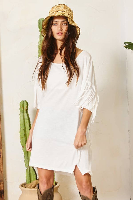 This White Fringe Back T-shirt Mini Dress is designed with a boat neckline and short drop-shoulder sleeves for a relaxed fit. The fringe back detailing adds a unique touch to this classic style. Perfect for a casual and comfortable look.